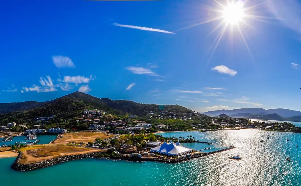 An aerial view of a Somersault marquee on a remote coastal site at Airlie Beach