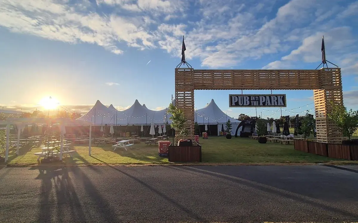 Marquees seen through the Pub in the Park entrance arch at sunset