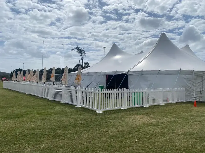 A 26 metre structure with picket fencing and umbrellas on a sports field