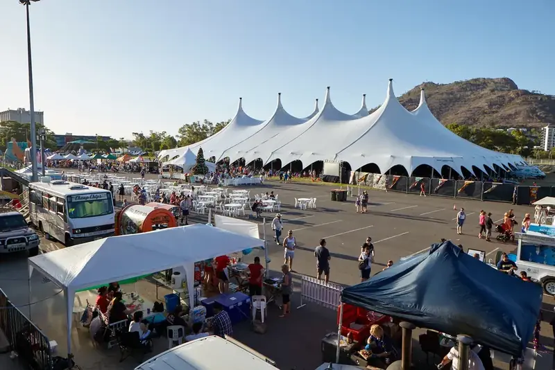 A Majestic event tent at a public festival with food stalls and crowds