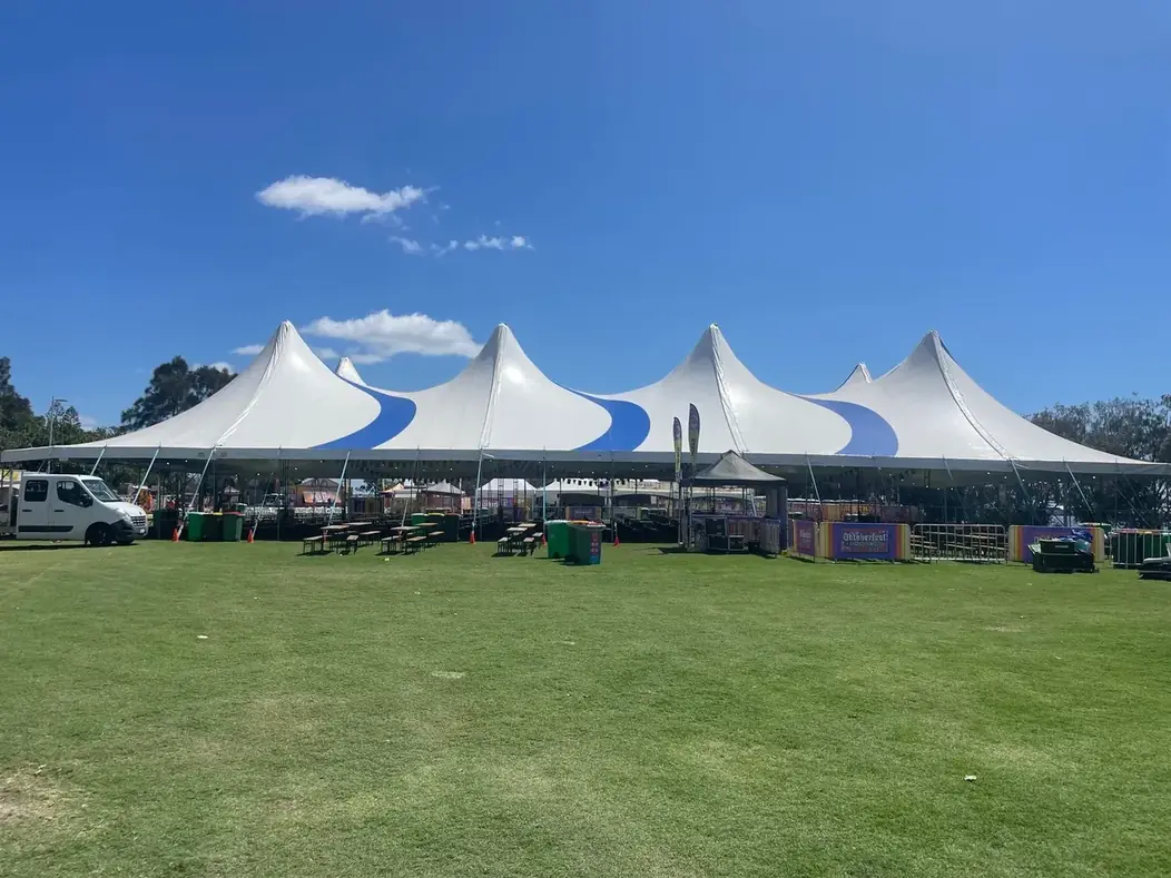 A completed Somersault marquee build on a sports ground with crew vehicles alongside